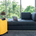 Suitcase in furnished holiday let, infant of sofa with laptop